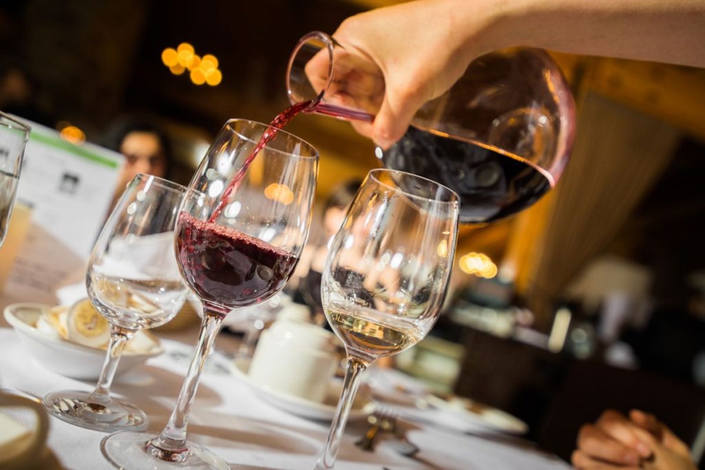 waiter pouring red wine to glass