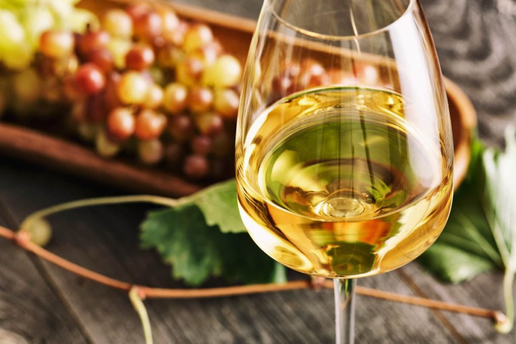 Glass of white French wine on vintage wooden table